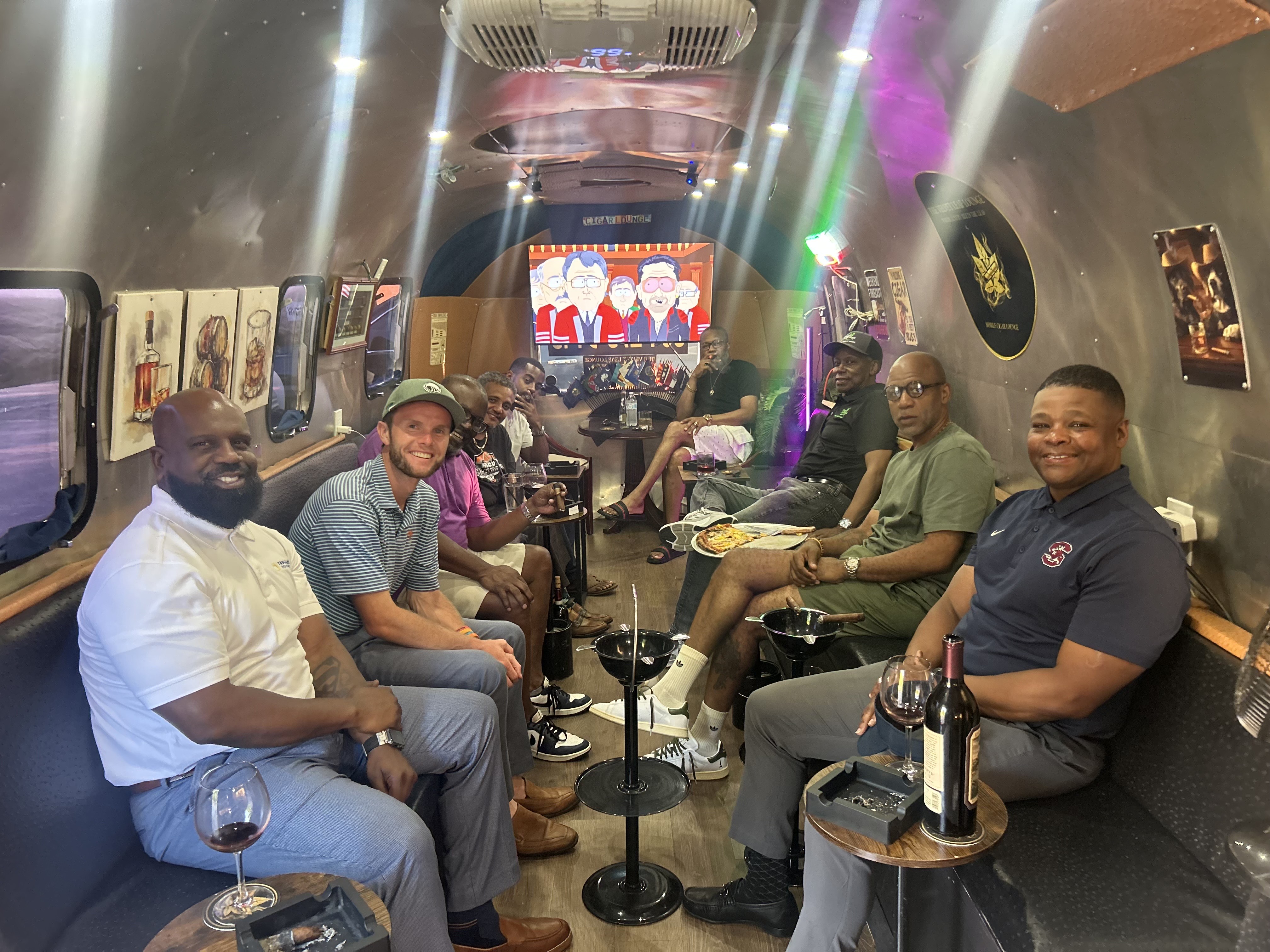 A group of guests celebrating together with cigars and wine inside the lounge