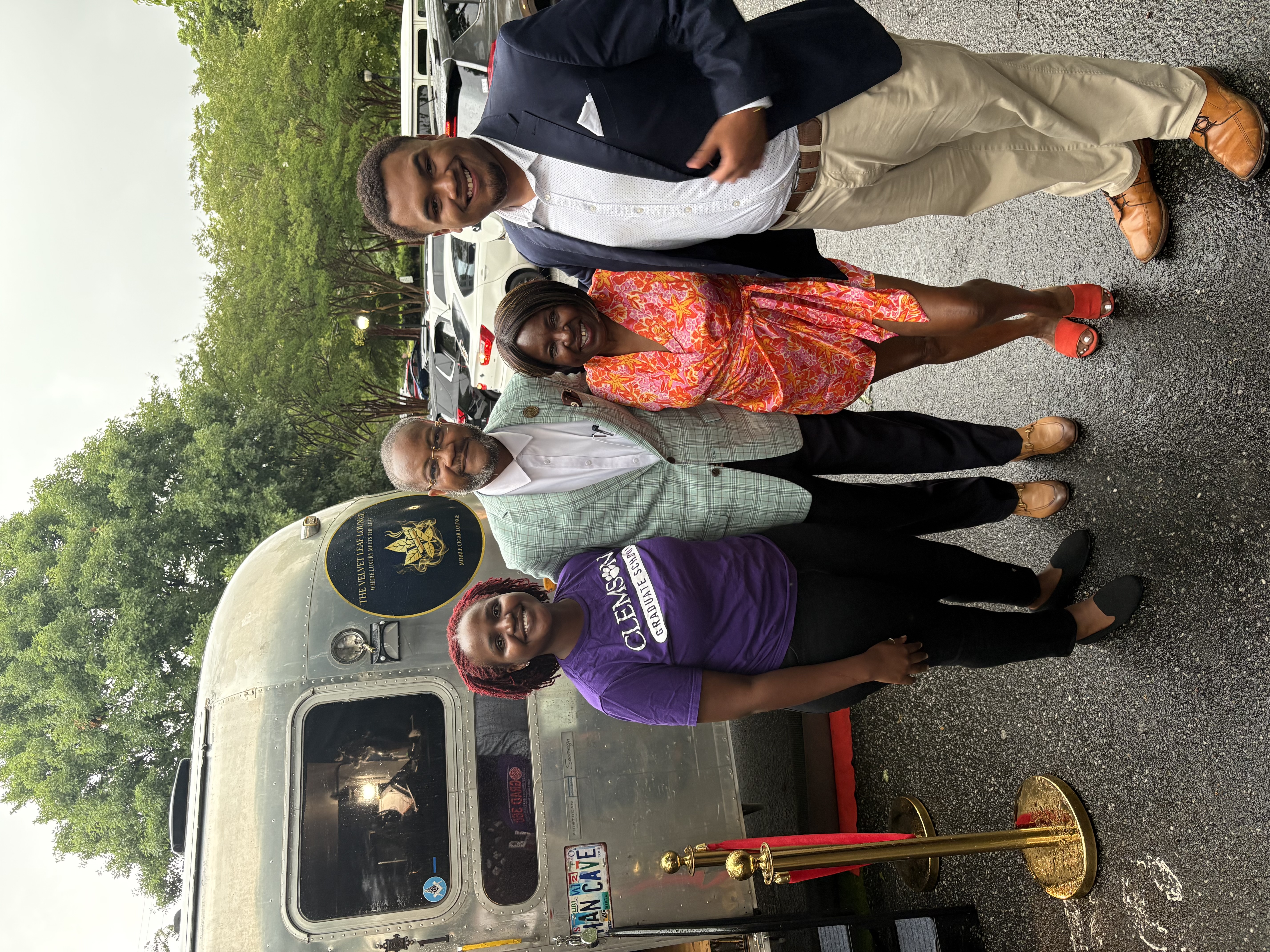 Guests posing together outside the Velvet Leaf Airstream at a community event
