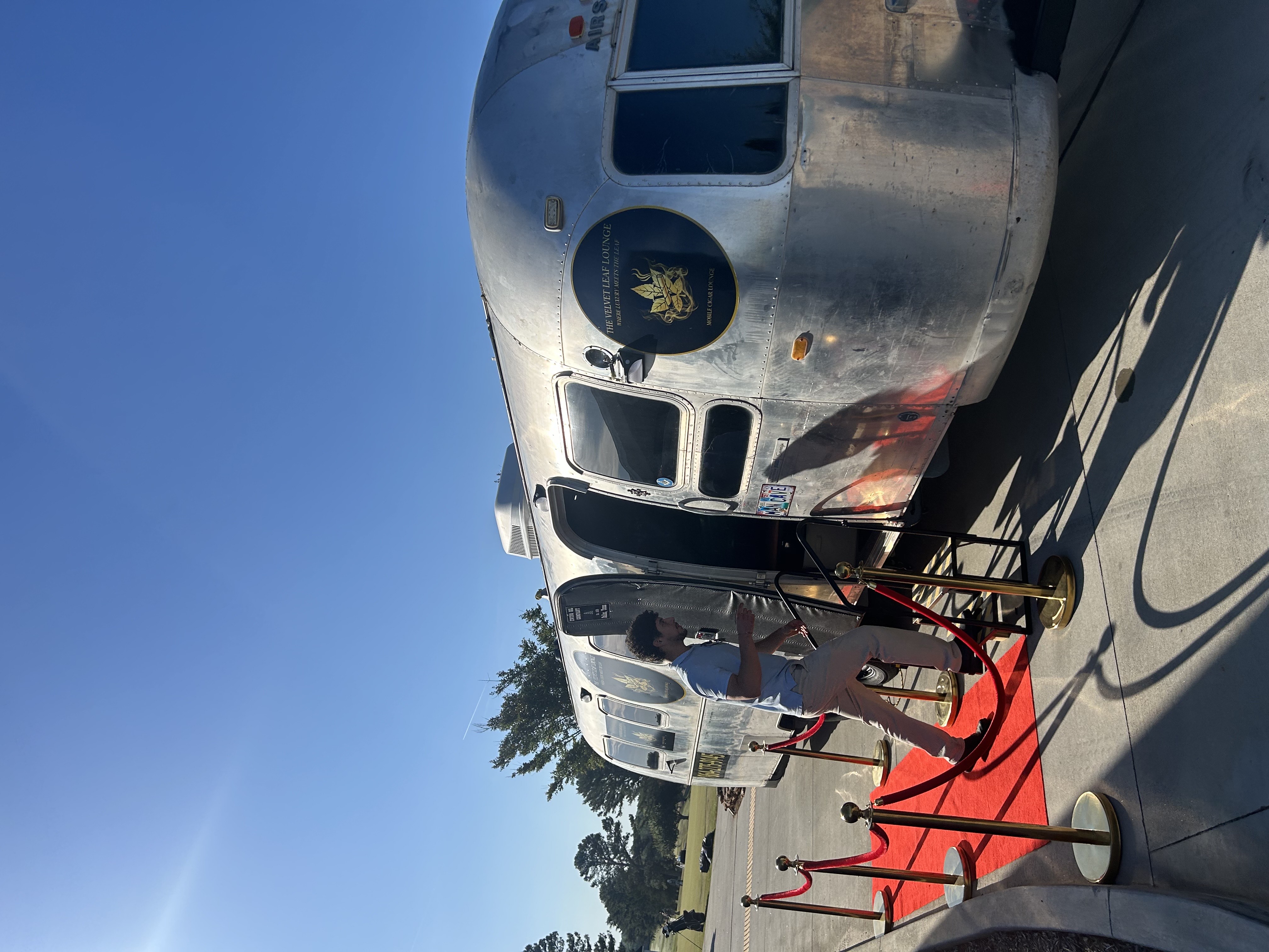A guest stepping up to the Airstream entrance beside the red carpet